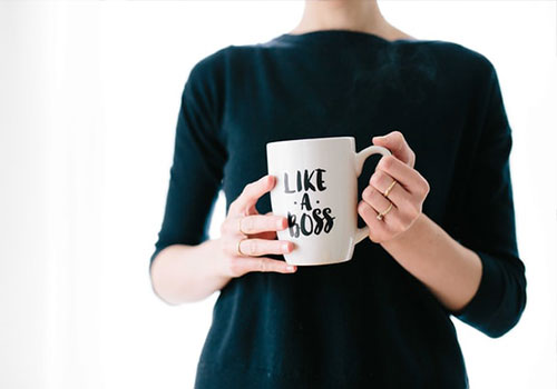 Femme tenant un mug avec écrit "Like a boss"